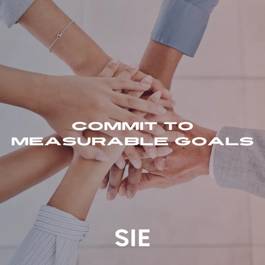 Team placing hands together in a circle to symbolize unity and collaboration while setting measurable sustainability and ITAD goals